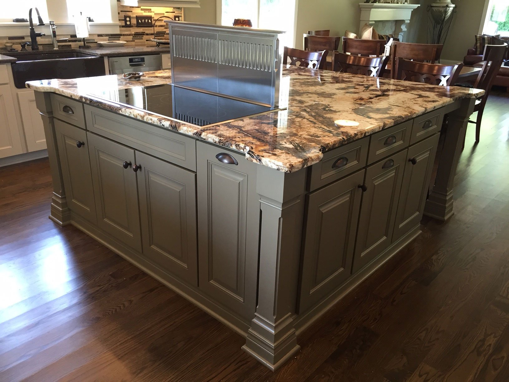 Large grey painted island topped with dramatic brown and cream granite