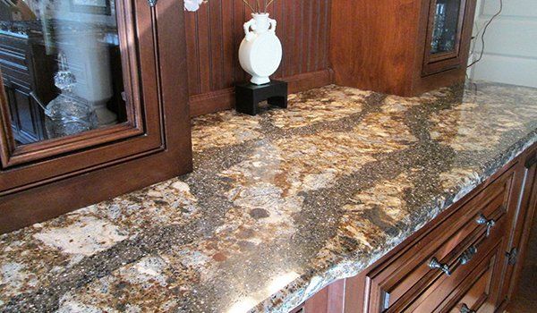 Brown and gold speckled quartz countertop running alongside cherry cabinets